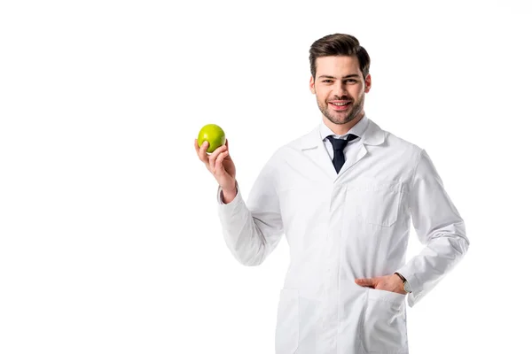 Portrait of smiling nutritionist in white coat with fresh apple in hand isolated on white — Stock Photo