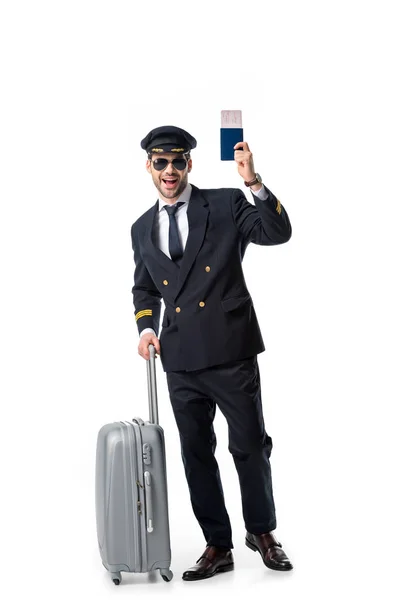 Piloto feliz con equipaje, pasaporte y billete aislado en blanco - foto de stock