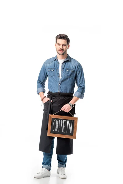 Joven camarero en delantal con pizarra abierta aislada en blanco — Stock Photo