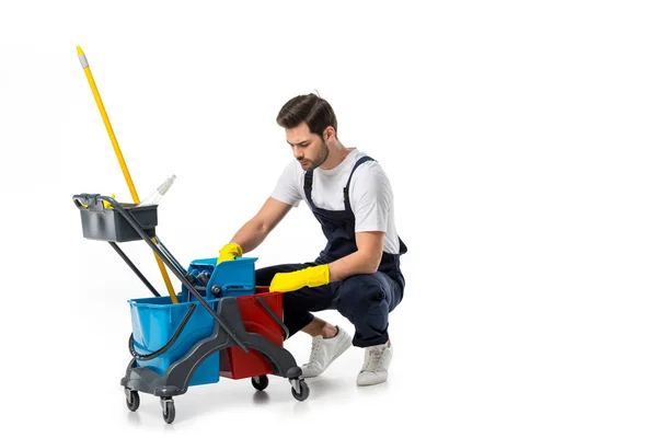 Detergente in uniforme e guanti di gomma con carrello isolato su bianco — Foto stock