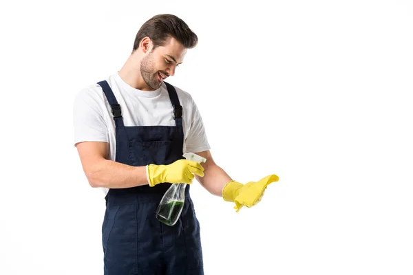 Retrato de limpiador sonriente en guantes de goma con detergente y trapo aislado en blanco - foto de stock