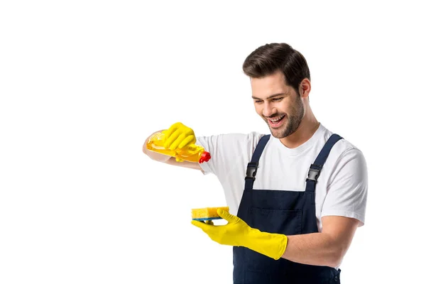 Portrait de nettoyant souriant dans des gants en caoutchouc avec détergent et éponge isolé sur blanc — Photo de stock