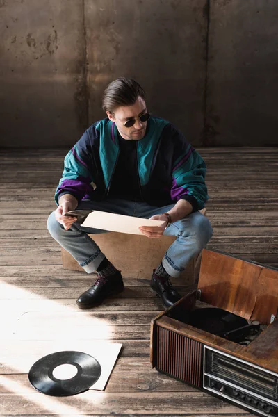 Guapo joven en vintage windcheater con vinilo tocadiscos - foto de stock