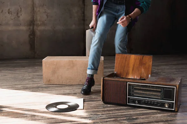 Cropped shot of man in vintage windcheater with vinyl record player — Stock Photo