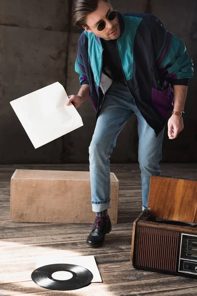 Handsome young man in vintage windcheater with vinyl record player — Stock Photo