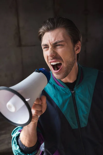 Jeune homme en colère dans vintage windcheater crier avec haut-parleur — Photo de stock