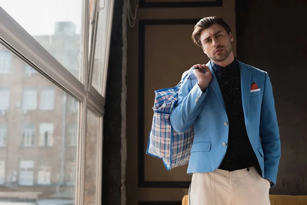 Elegante giovane uomo con borsone vintage con cerniera sulla spalla — Foto stock