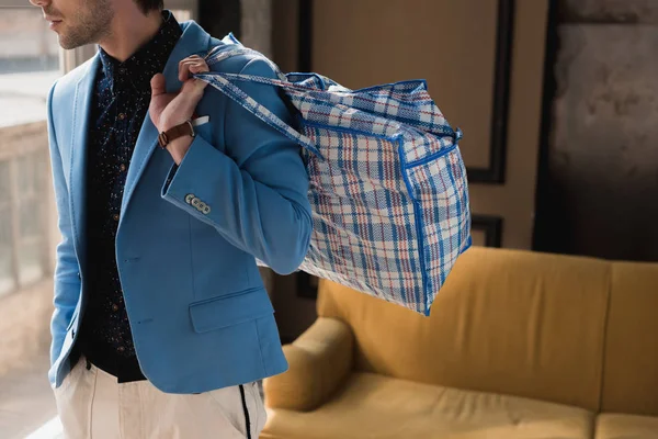Обрезанный снимок молодого человека с винтажной сумкой из молнии — стоковое фото