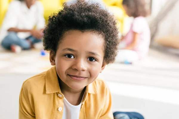 Selective focus of smiling african american boy with family behind at home — Stock Photo