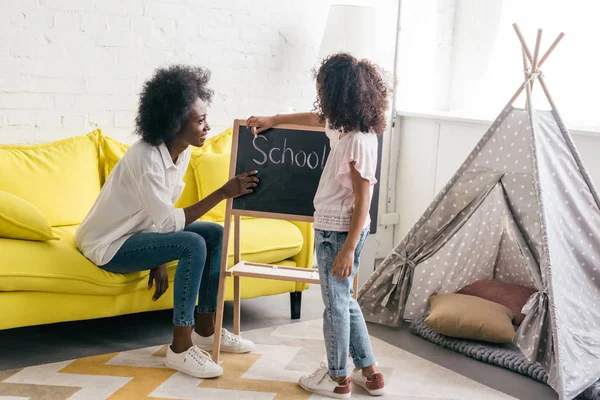 Donna afro-americana che studia con la figlia a casa — Foto stock