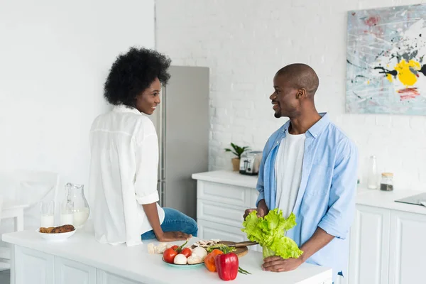 Couple afro-américain avec des légumes frais sur la table le matin à la maison — Photo de stock