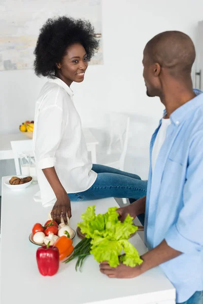 Pareja afroamericana con verduras frescas en la mesa por la mañana en casa - foto de stock