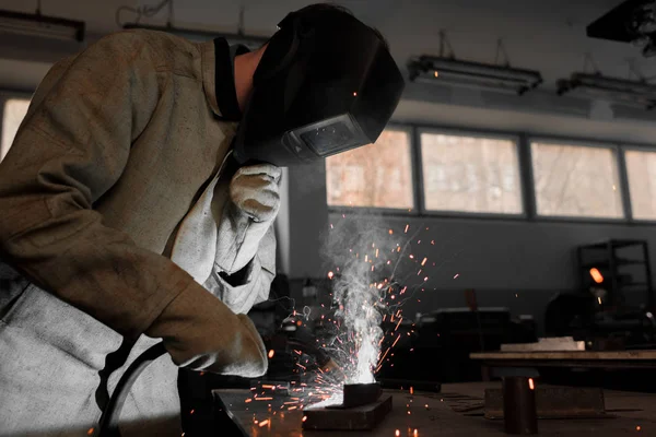 Manufacture worker welding metal with sparks at factory — Stock Photo