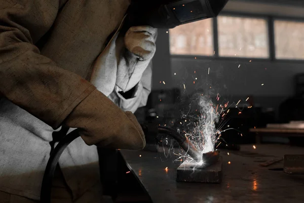 Immagine ritagliata del lavoratore di fabbricazione saldatura del metallo con scintille in fabbrica — Foto stock