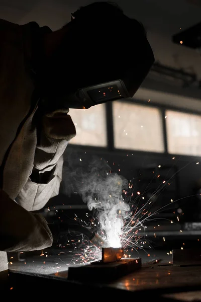 Welder in protection mask working with metal at factory — Stock Photo