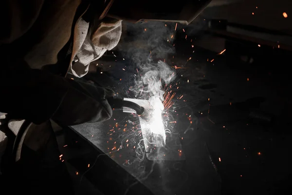 Tiro cortado do trabalhador em metal de soldagem máscara de proteção na fábrica — Fotografia de Stock