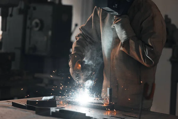 Cropped shot of worker in protection mask welding metal at factory — Stock Photo