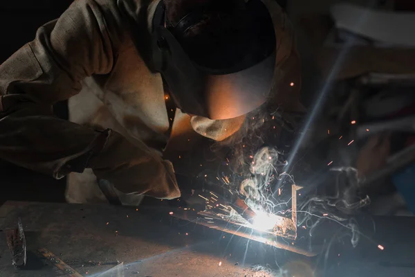 Manufacture worker welding metal with sparks at factory — Stock Photo