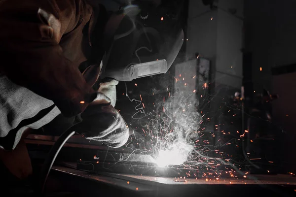 Вид сбоку работника в защитной маске сварки металла на заводе — Stock Photo