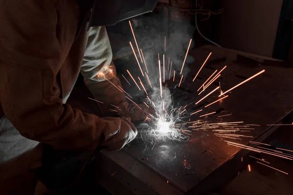Immagine ritagliata del saldatore nella maschera di protezione che lavora con il metallo in fabbrica — Foto stock