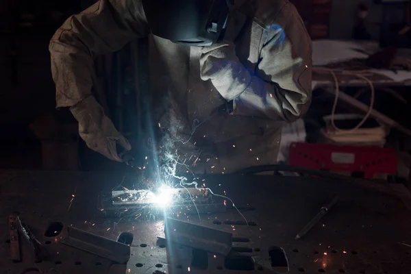 Imagem cortada de soldador em máscara de proteção trabalhando com metal na fábrica — Fotografia de Stock