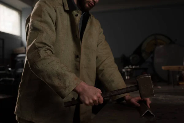 Cropped shot of male worker hammering metal part at factory — Stock Photo