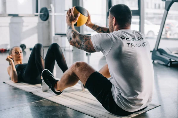 Masculino personal trainer e esportista fazendo exercícios com bola no ginásio — Fotografia de Stock