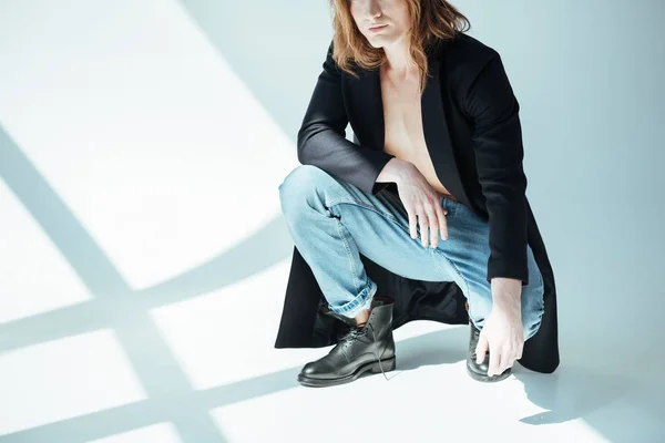 Abgeschnittene Ansicht von sexy Mann posiert in Jacke und Jeans, auf grau — Stockfoto