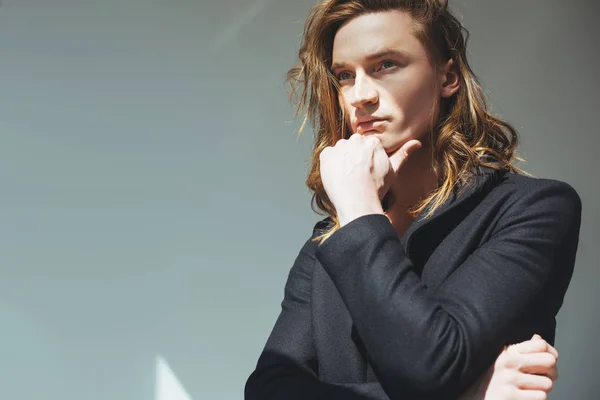 Handsome pensive man in black jacket, on grey — Stock Photo