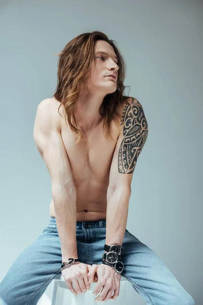 Sexy tattooed shirtless man in jeans, isolated on grey — Stock Photo