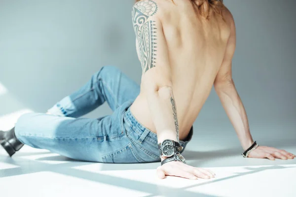 Vue arrière de sexy homme torse nu avec tatouage, sur gris — Photo de stock