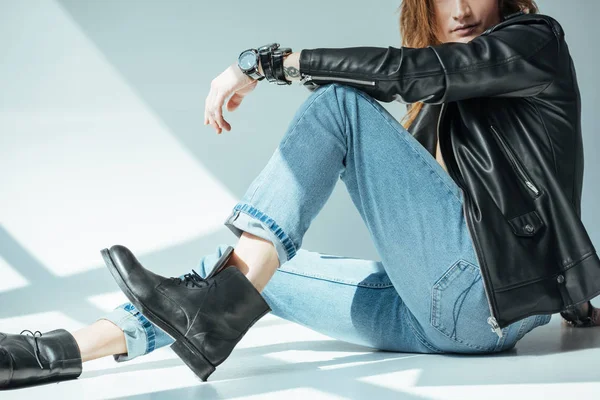 Cropped view of stylish man posing in jeans and black leather jacket, on grey — Stock Photo