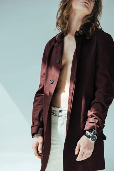 Cropped view of shirtless man posing in trench coat, on grey — Stock Photo