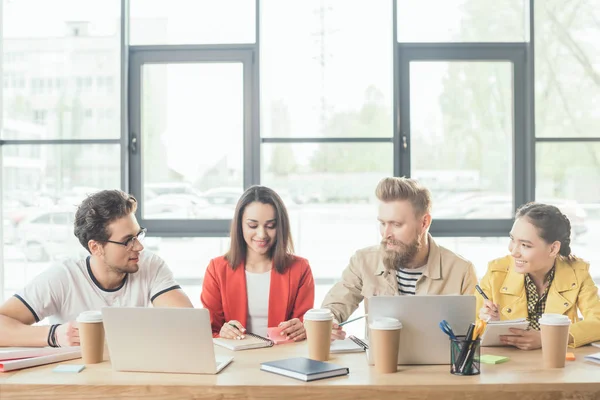 Diverse business team working on laptops in light workspace — Stock Photo