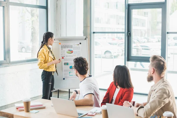 Successful business people looking at woman presenter in modern light office — Stock Photo