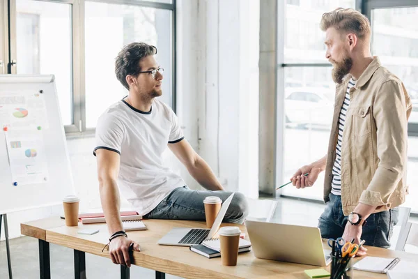 Empresários bem sucedidos discutindo projeto em escritório leve moderno — Fotografia de Stock