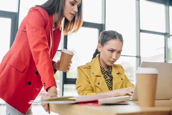 Donne d'affari professionali che guardano lo schermo del computer portatile in ufficio moderno — Foto stock