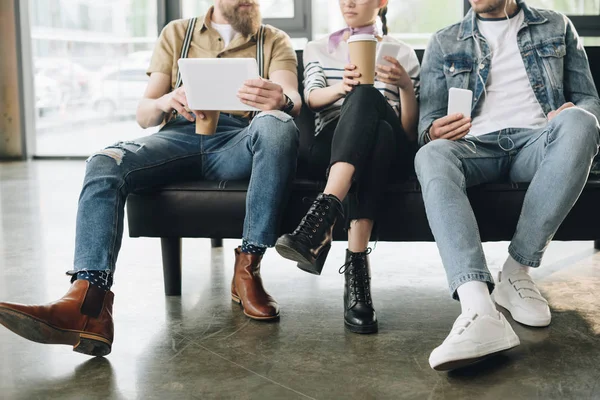 Abgeschnittene Ansicht von Geschäftsleuten, die sich in modernen hellen Büros ausruhen und Geräte in der Hand halten — Stockfoto