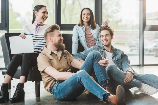 Erfolgreiche Geschäftsleute sitzen und ruhen zusammen in modernem hellen Büro — Stockfoto