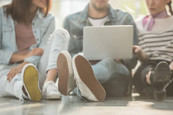 Vista ritagliata dei colleghi seduti sul pavimento con laptop in spazio di lavoro leggero — Foto stock