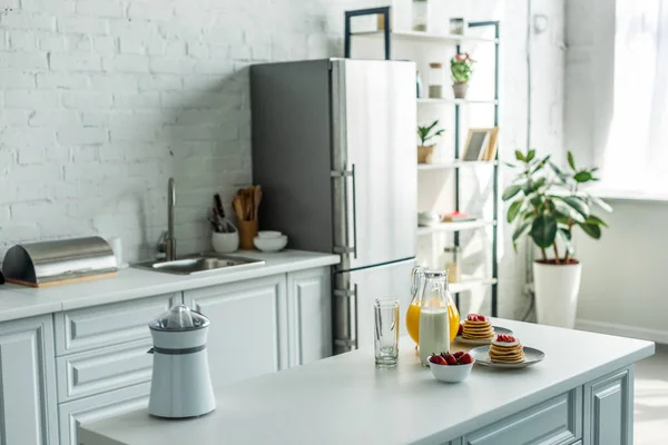 Інтер'єр сучасної світлої кухні з холодильником і кухонними прилавками — стокове фото