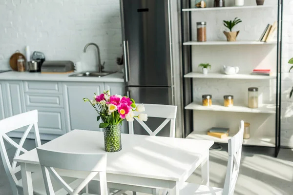 Interieur der modernen hellen Küche mit Bouquet auf Holztisch — Stockfoto