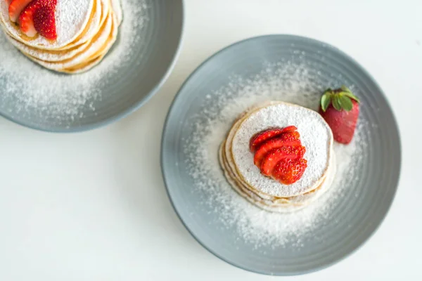 Erhöhte Ansicht von Pfannkuchen mit reifen Erdbeeren auf dem Tisch in der Küche — Stockfoto