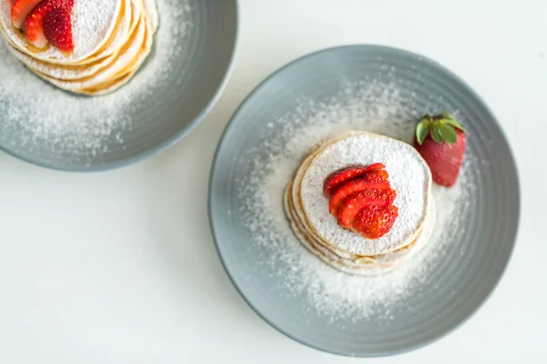 Vista elevada de panqueques con fresas maduras en la mesa en la cocina — Stock Photo