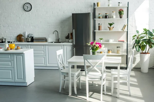 Intérieur de cuisine moderne et lumineuse avec table et chaises — Photo de stock