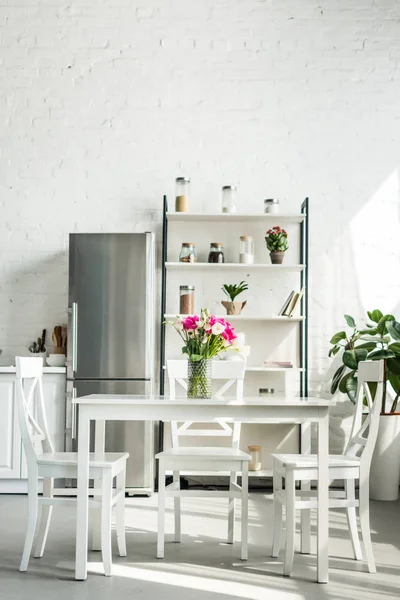Interieur der modernen hellen Küche mit Blumenstrauß auf dem Tisch — Stockfoto
