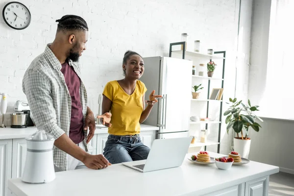 Feliz casal afro-americano com laptop na cozinha — Fotografia de Stock