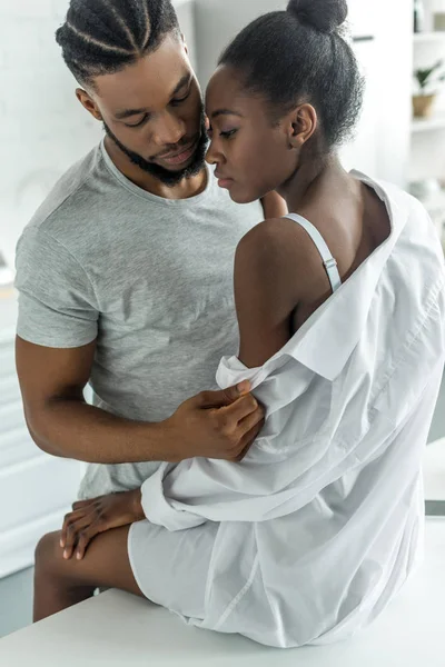 African american boyfriend undressing girlfriend at kitchen — Stock Photo