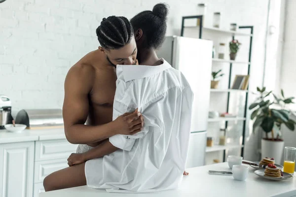 Africano americano namorado beijando namorada pescoço na cozinha — Fotografia de Stock