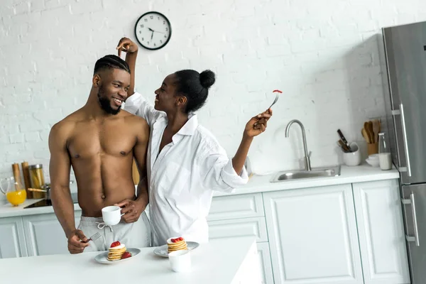 Africano americano fidanzata toccare fidanzato testa a cucina — Foto stock